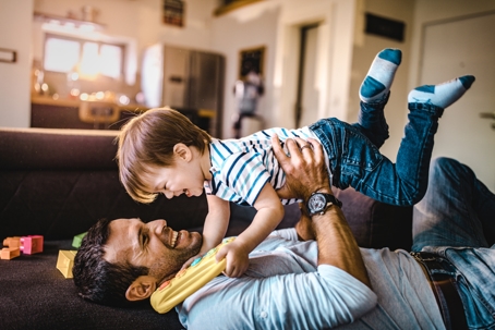father playing with son inside home