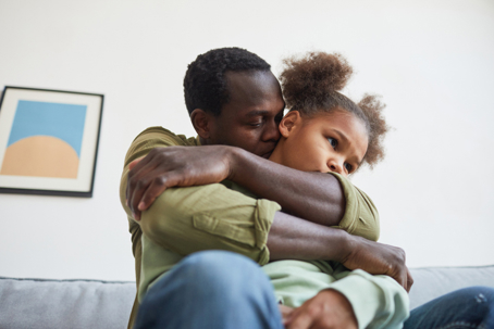 father hugging sad daughter