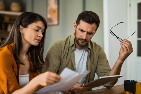couple talking seriously while reviewing documents