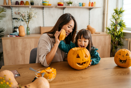 mother and daughter carving a pumpkin